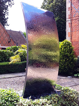 Sail - mirror polished surface used to bring light, colour and movement to a  private garden